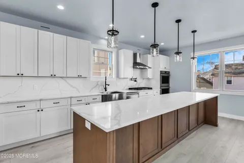 a large kitchen with stainless steel appliances kitchen island a large counter top a stove a refrigerator and a sink