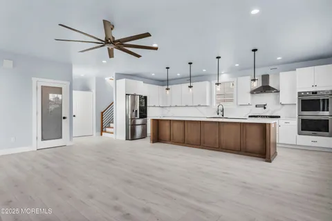 a kitchen with stainless steel appliances a sink a stove top oven a counter space and cabinets