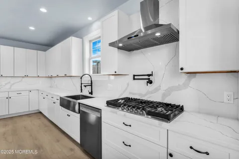 a kitchen with stainless steel appliances kitchen island a stove a sink and a refrigerator