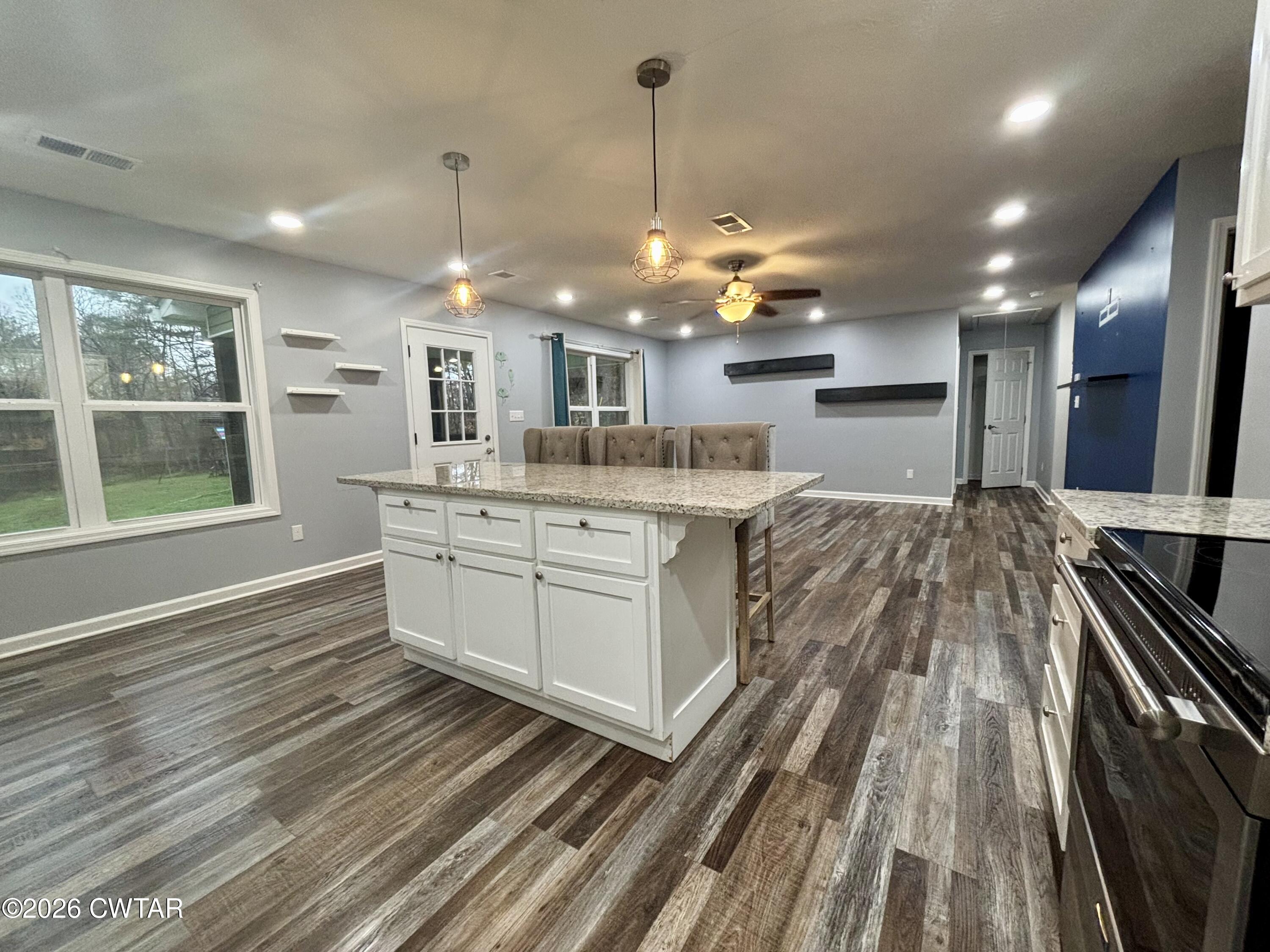 129 Gunner Lane Lexington, TN 38351 - Photo 3 of 19 a kitchen with kitchen island a stove a sink and a wooden floors