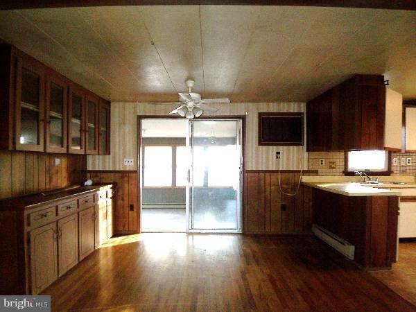 143 Holiday Road Cross Junction, VA 22625 - Photo 8 of 22 a kitchen with granite countertop wooden floors and stainless steel appliances