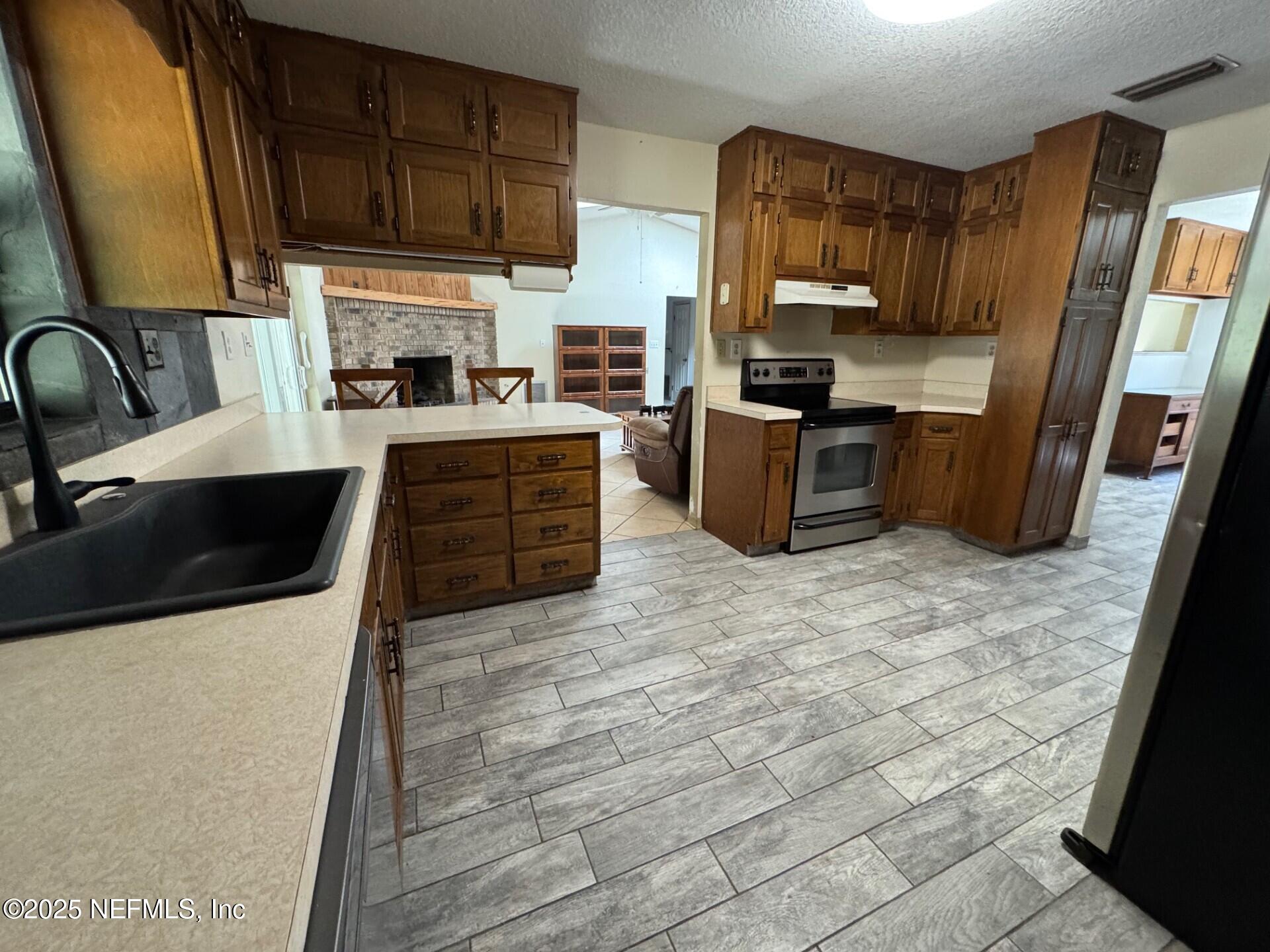229 Davis Lake Road Palatka, FL 32177 - Photo 11 of 73 a kitchen with stainless steel appliances a stove sink microwave and cabinets
