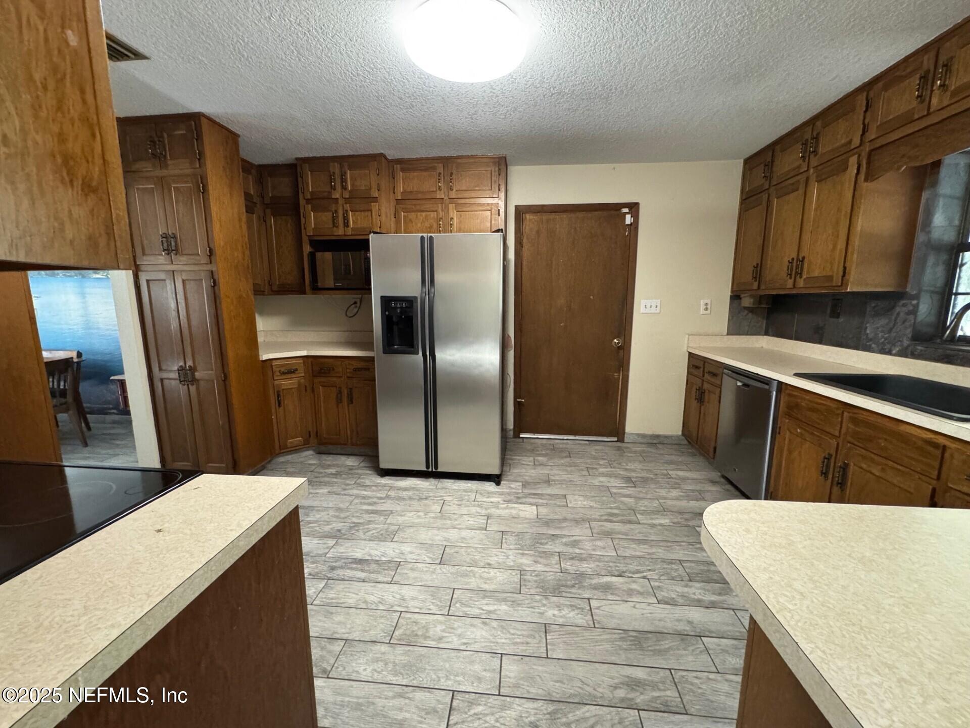 229 Davis Lake Road Palatka, FL 32177 - Photo 12 of 73 a kitchen with stainless steel appliances a refrigerator a stove a sink a counter space and cabinets