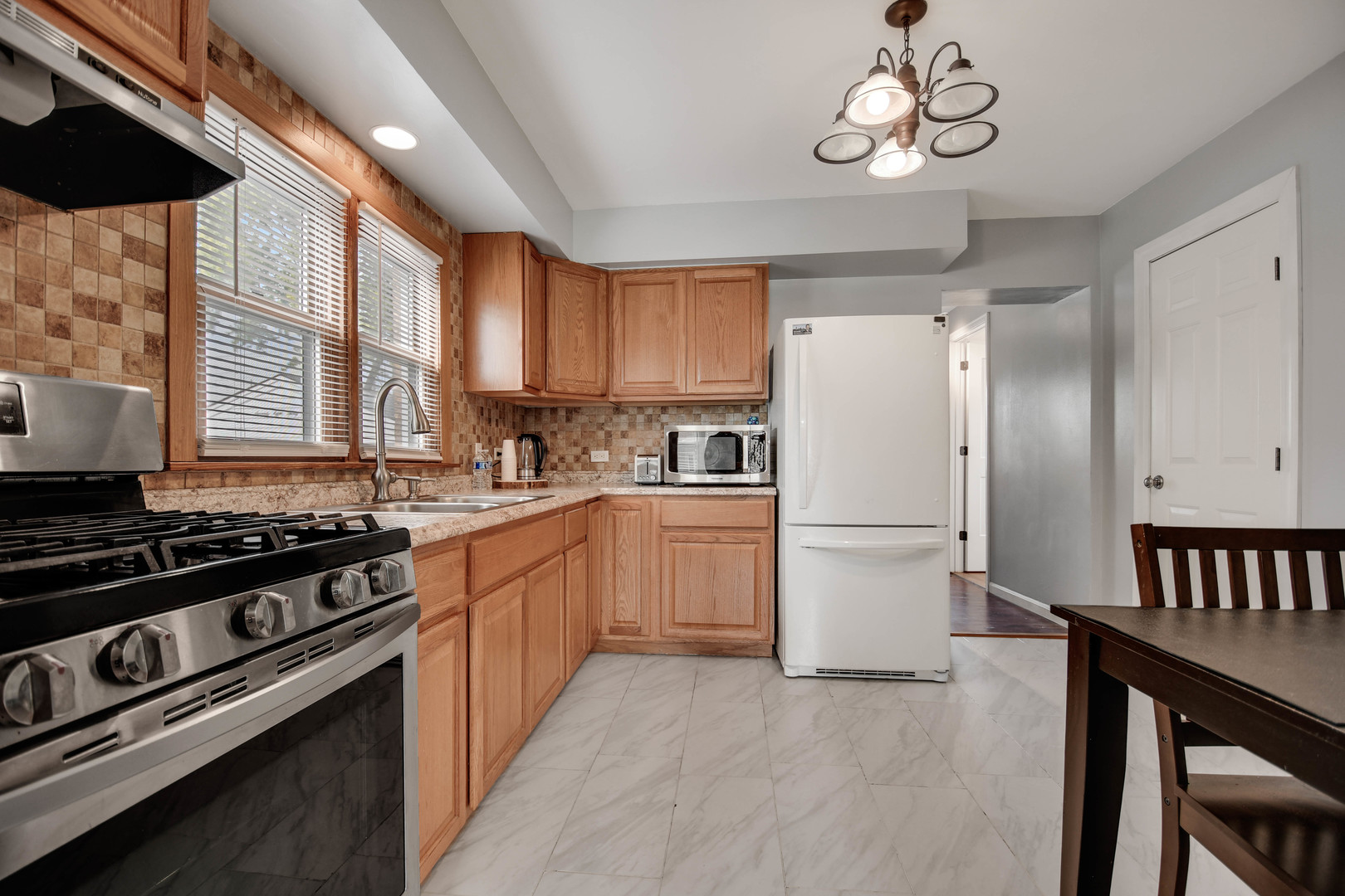 7828 Suburban Lane Bridgeview, IL 60455 - Photo 5 of 20 a kitchen with a stove a refrigerator and a table