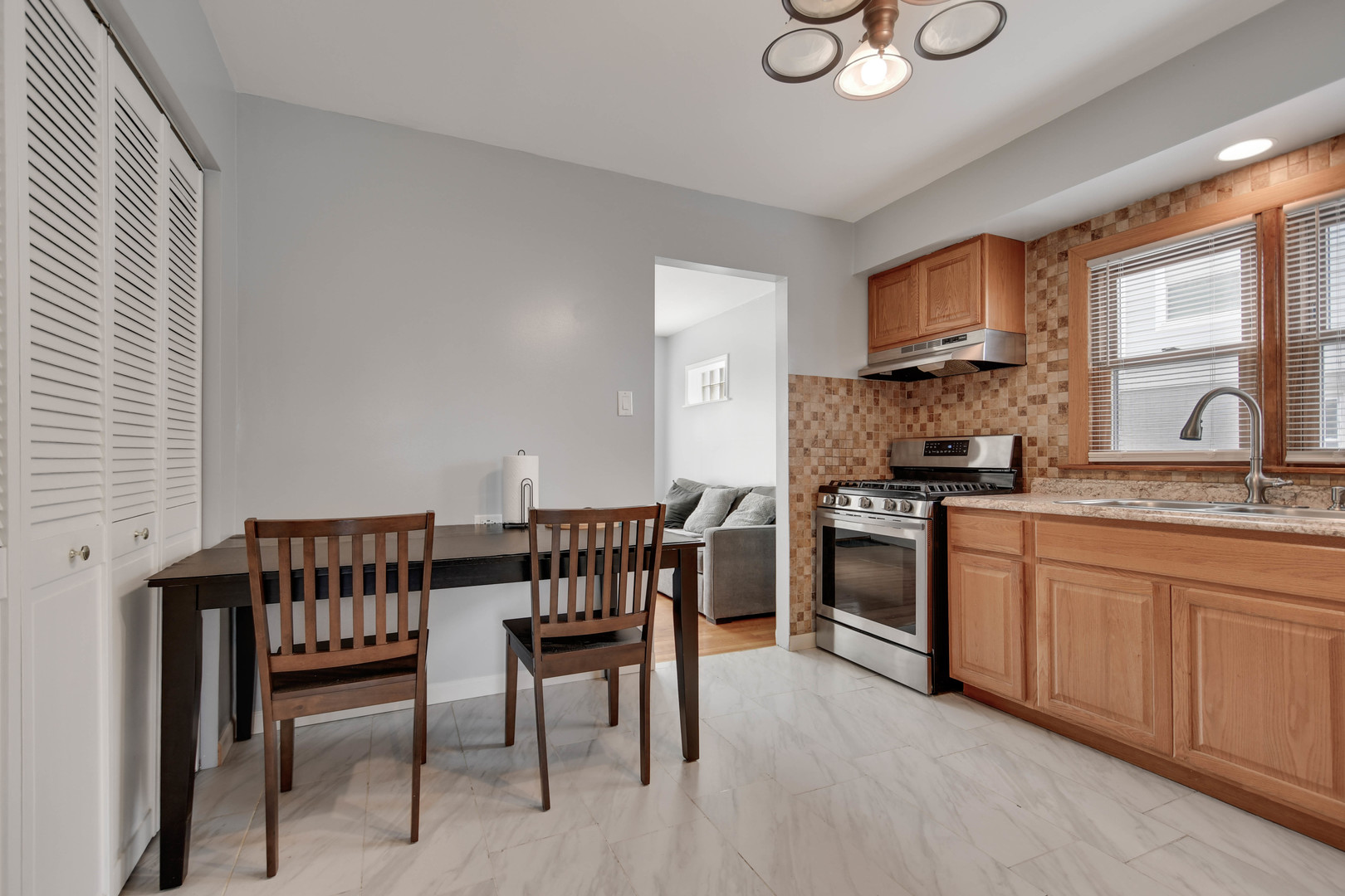 7828 Suburban Lane Bridgeview, IL 60455 - Photo 7 of 20 a kitchen with a dining table chairs and white appliances