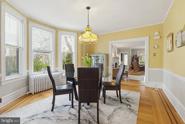 a dining room with furniture a chandelier and wooden floor