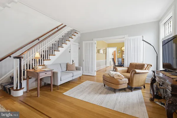 a living room with furniture and a dining table with wooden floor