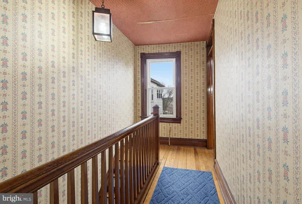 a view of a hallway with wooden floor and staircase