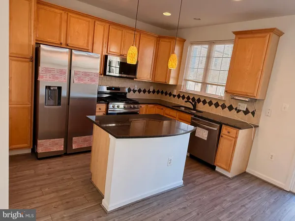 a kitchen with granite countertop a sink a counter space appliances and cabinets
