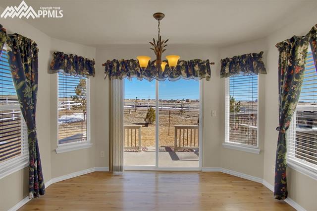 9162 Rockingham Drive Peyton, CO 80831 - Photo 15 of 35 Casual dining area surrounded by windows with walkout to back patio.