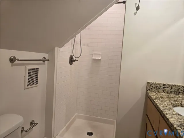 a bathroom with a granite countertop sink a mirror and shower