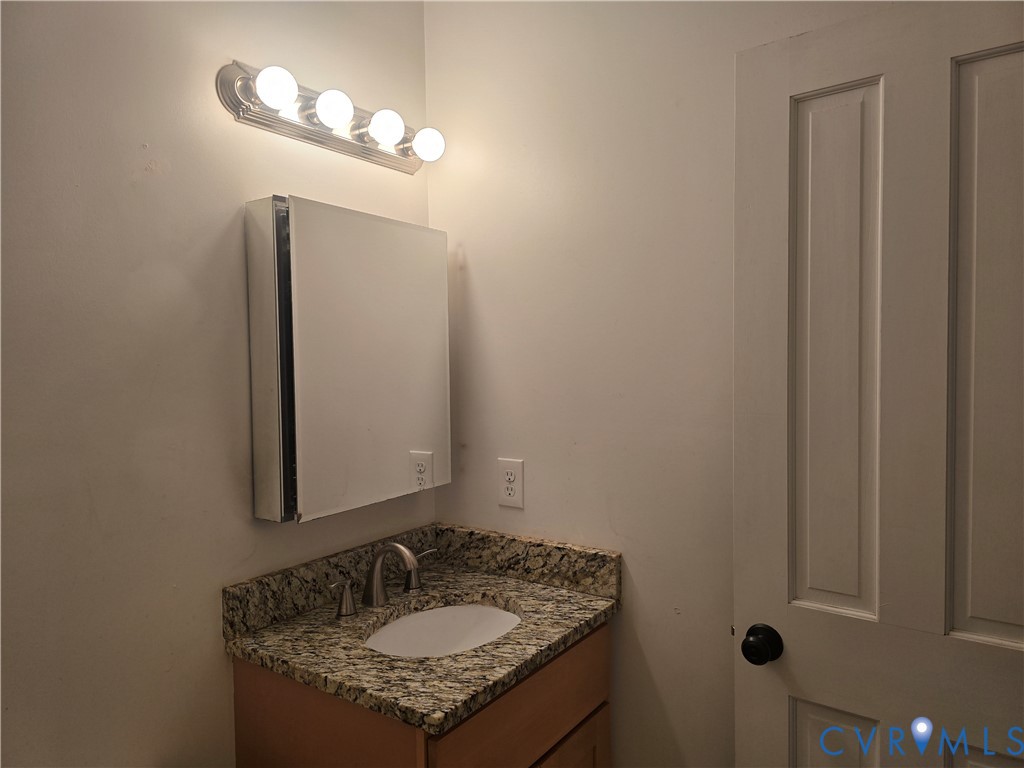 2106 Parkwood Avenue, Unit 1 Richmond, VA 23220 - Photo 18 of 20 a bathroom with a granite countertop sink and a mirror