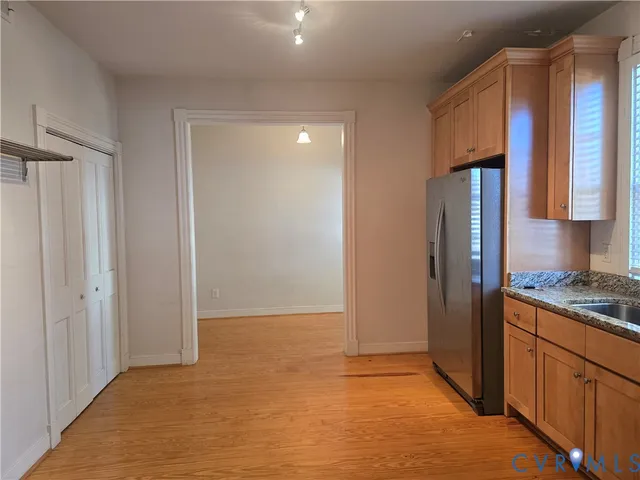 a view of a kitchen with wooden floor and electronic appliances