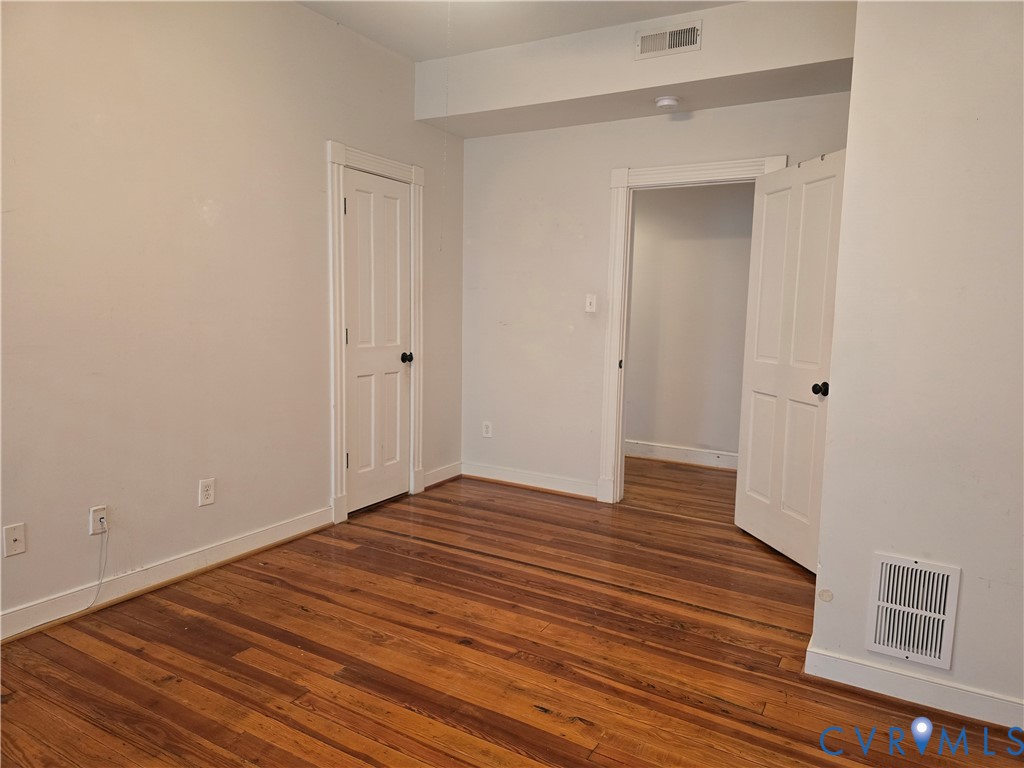 2106 Parkwood Avenue, Unit 1 Richmond, VA 23220 - Photo 9 of 20 a view of an empty room with wooden floor and a window