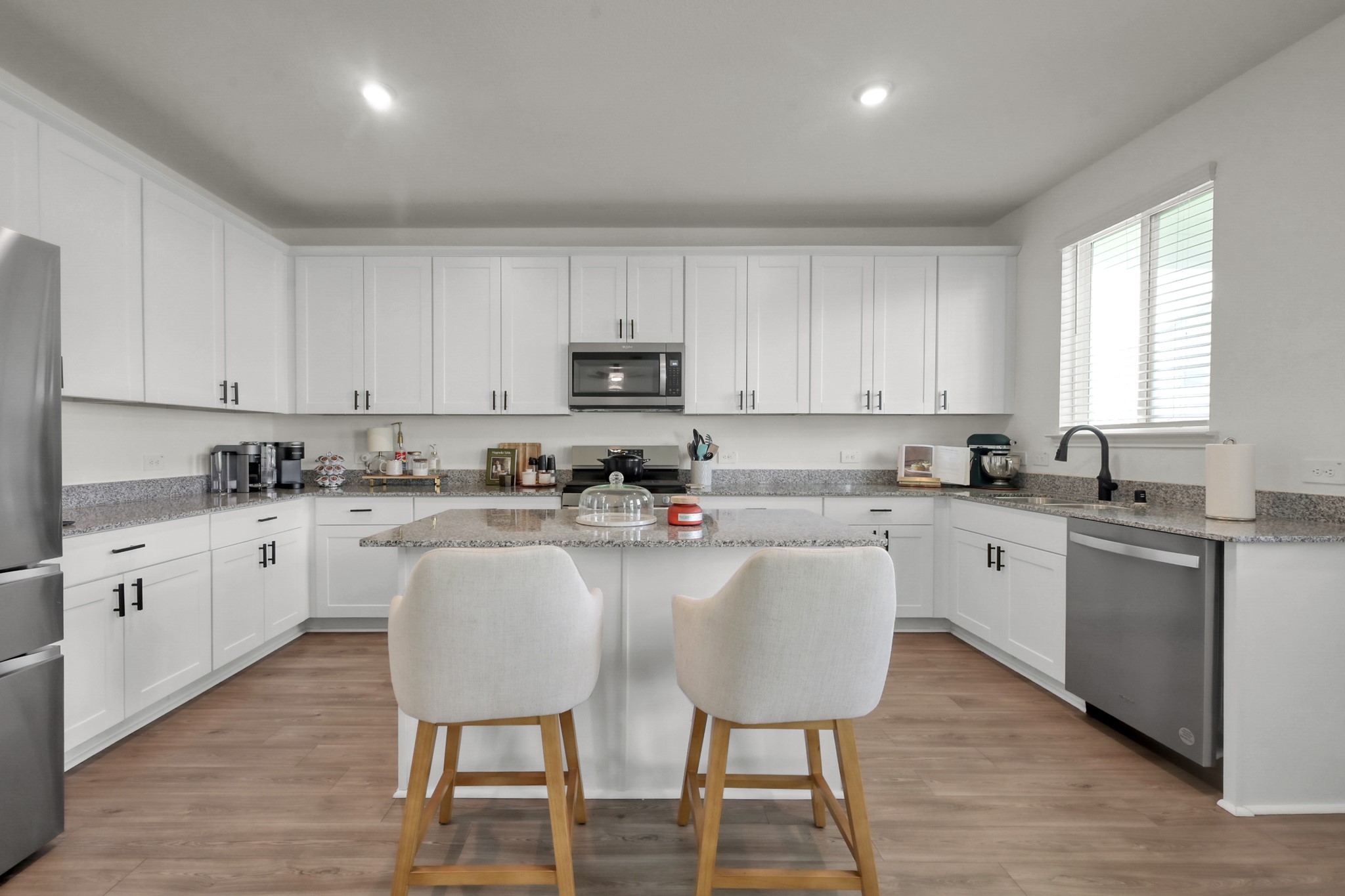 23562 Glenbuck Street Spring, TX 77373 - Photo 9 of 30 a kitchen with granite countertop white cabinets white appliances with chair and dining table