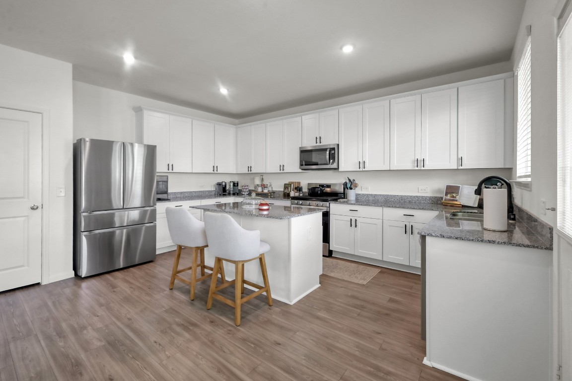 23562 Glenbuck Street Spring, TX 77373 - Photo 10 of 30 a kitchen with stainless steel appliances granite countertop a white cabinets and a refrigerator