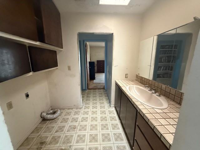 909 Railroad Street Rochester, TX 79544 - Photo 13 of 19 Laundry Room featuring vanity and decorative backsplash