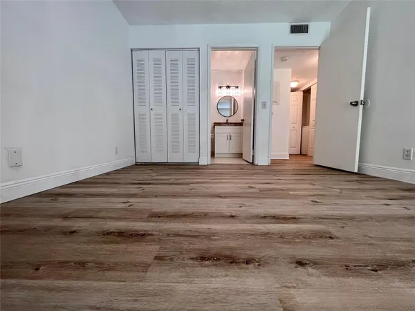 a view of a room with wooden floor and mirror