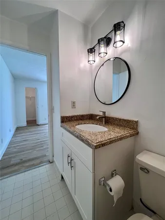 a en suite bathroom with a granite countertop sink and a mirror
