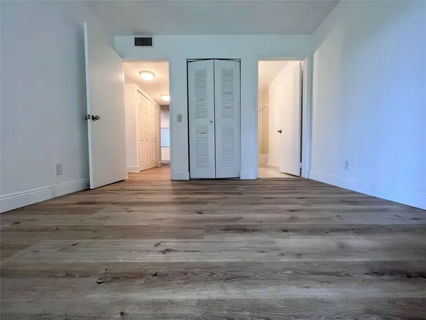 an empty room with wooden floor and window