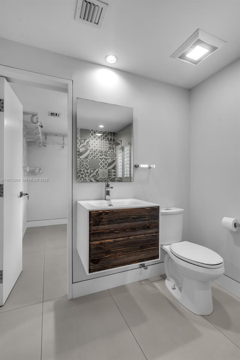 1632 Southwest 12th Street Miami, FL 33135 - Photo 22 of 43 a bathroom with a toilet a sink and mirror