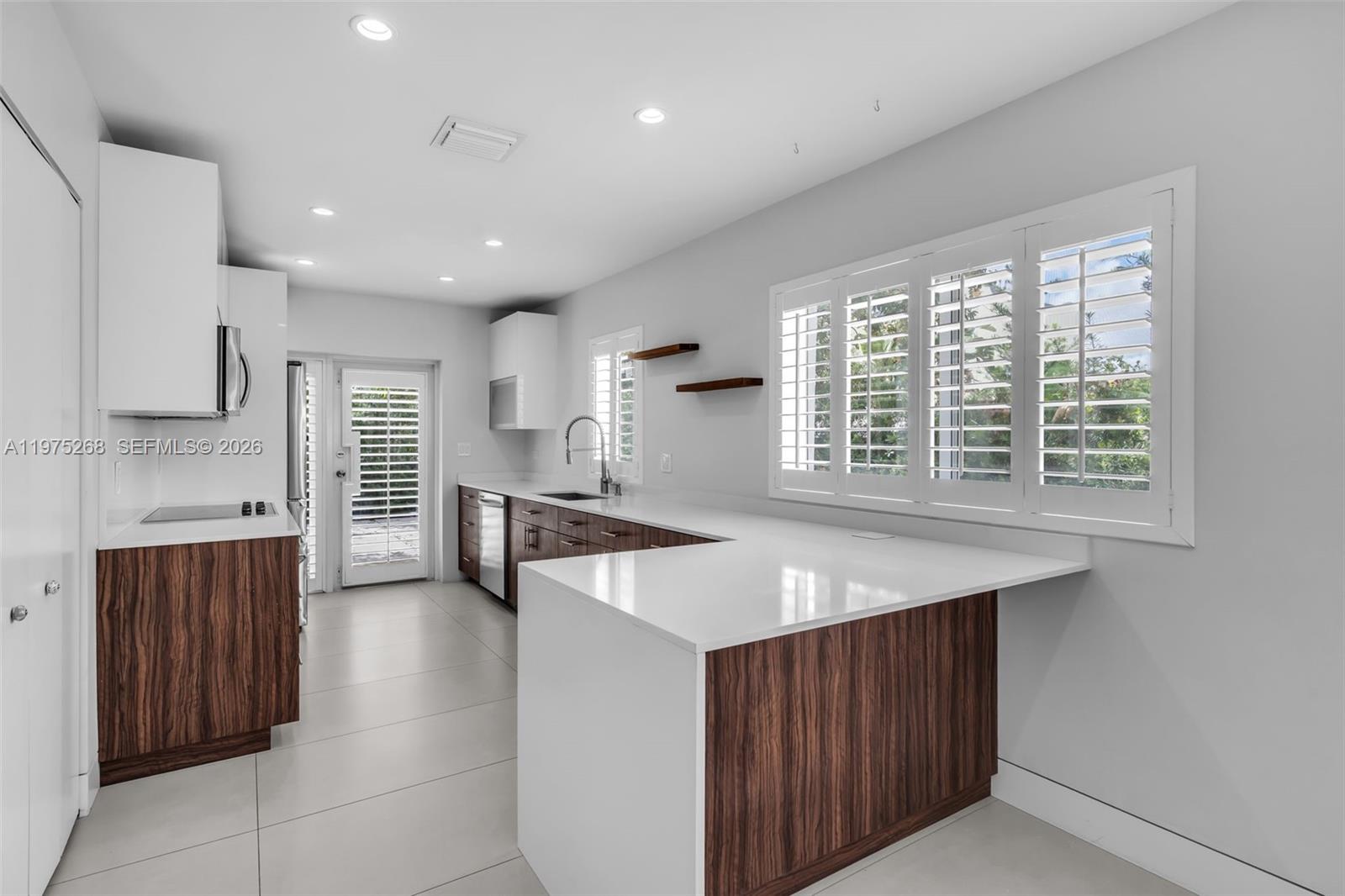 1632 Southwest 12th Street Miami, FL 33135 - Photo 4 of 43 a kitchen with stainless steel appliances granite countertop a sink a stove a refrigerator and island