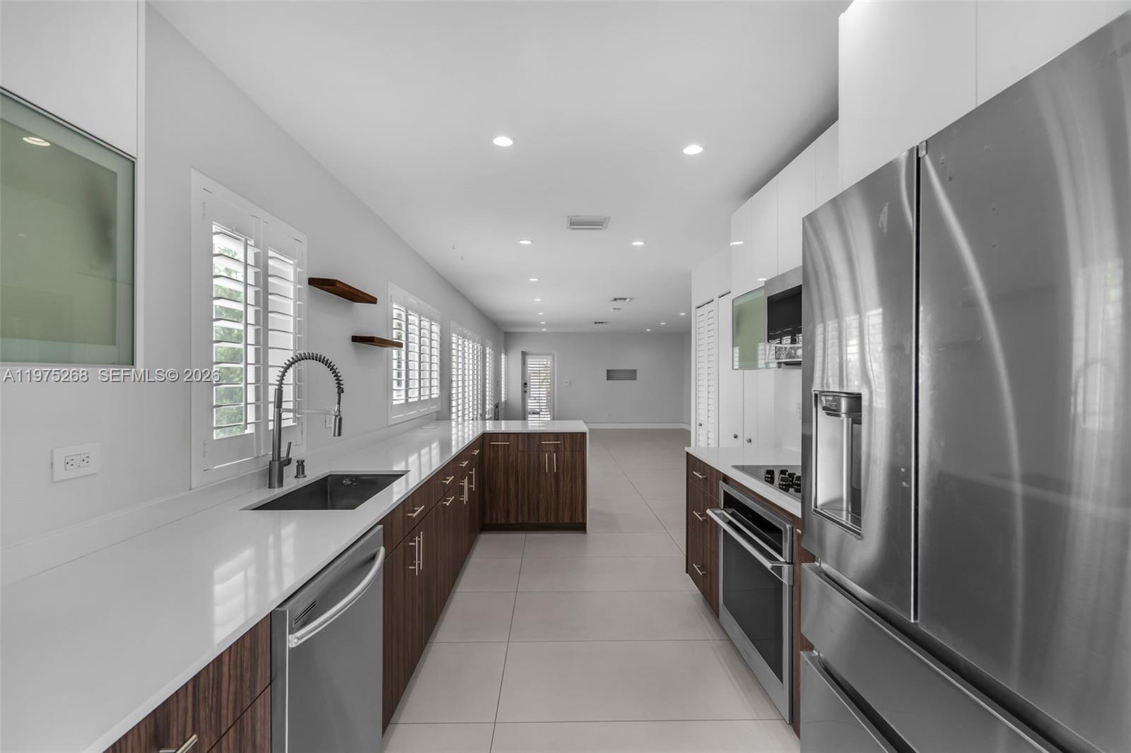 1632 Southwest 12th Street Miami, FL 33135 - Photo 6 of 43 a kitchen with stainless steel appliances granite countertop a refrigerator a sink and a stove