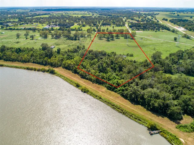 an aerial view of a residential houses with outdoor space and trees