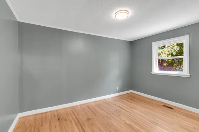 a view of a room with wooden floor and fan
