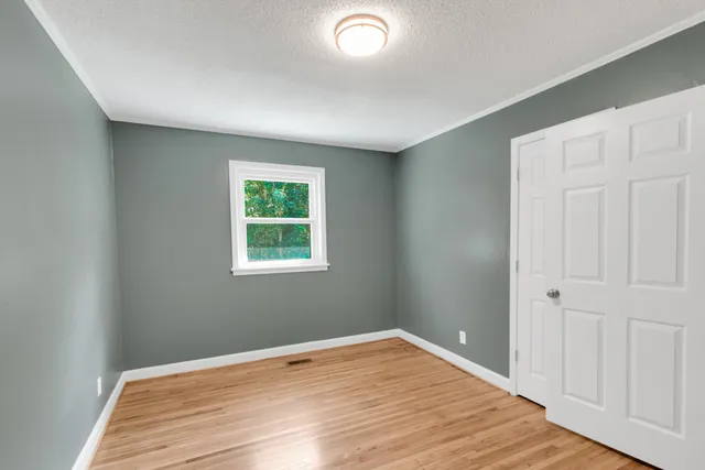 a white house with a big yard and large trees