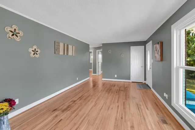 a view of empty room with wooden floor and cabinet