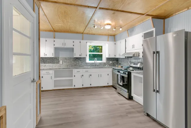 a large kitchen with a stove a sink dishwasher and a refrigerator
