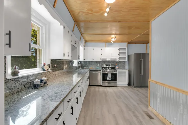 a kitchen with stainless steel appliances granite countertop a stove a refrigerator and a sink