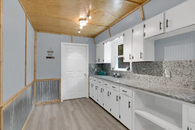 a view of a hallway with wooden floor and a window