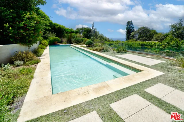 a view of a living room with wooden floor and a book shelf