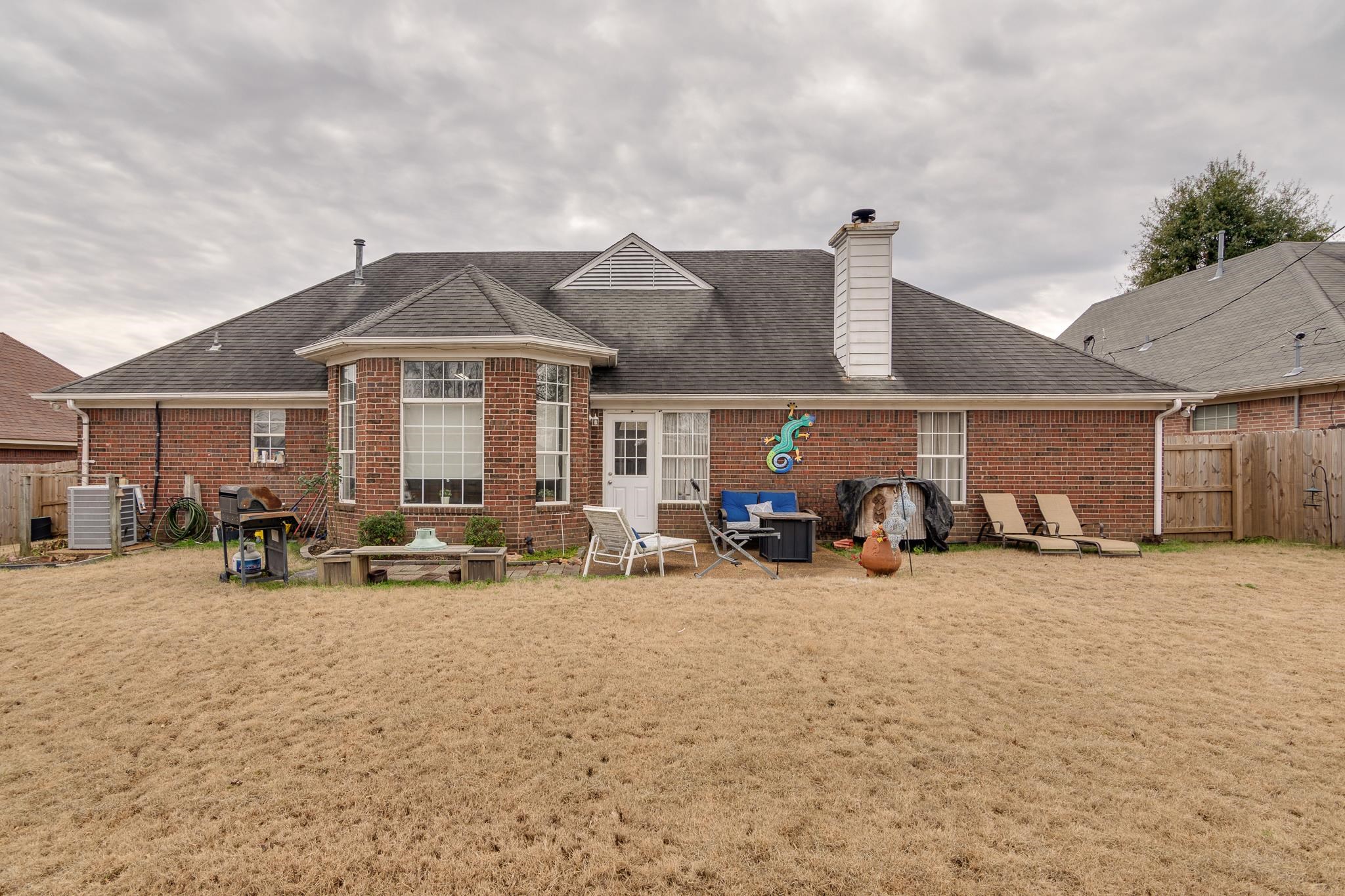 7314 Patsy Circle North Memphis, TN 38125 - Photo 23 of 28 Back of property featuring a shingled roof, a chimney, brick siding, and a patio area