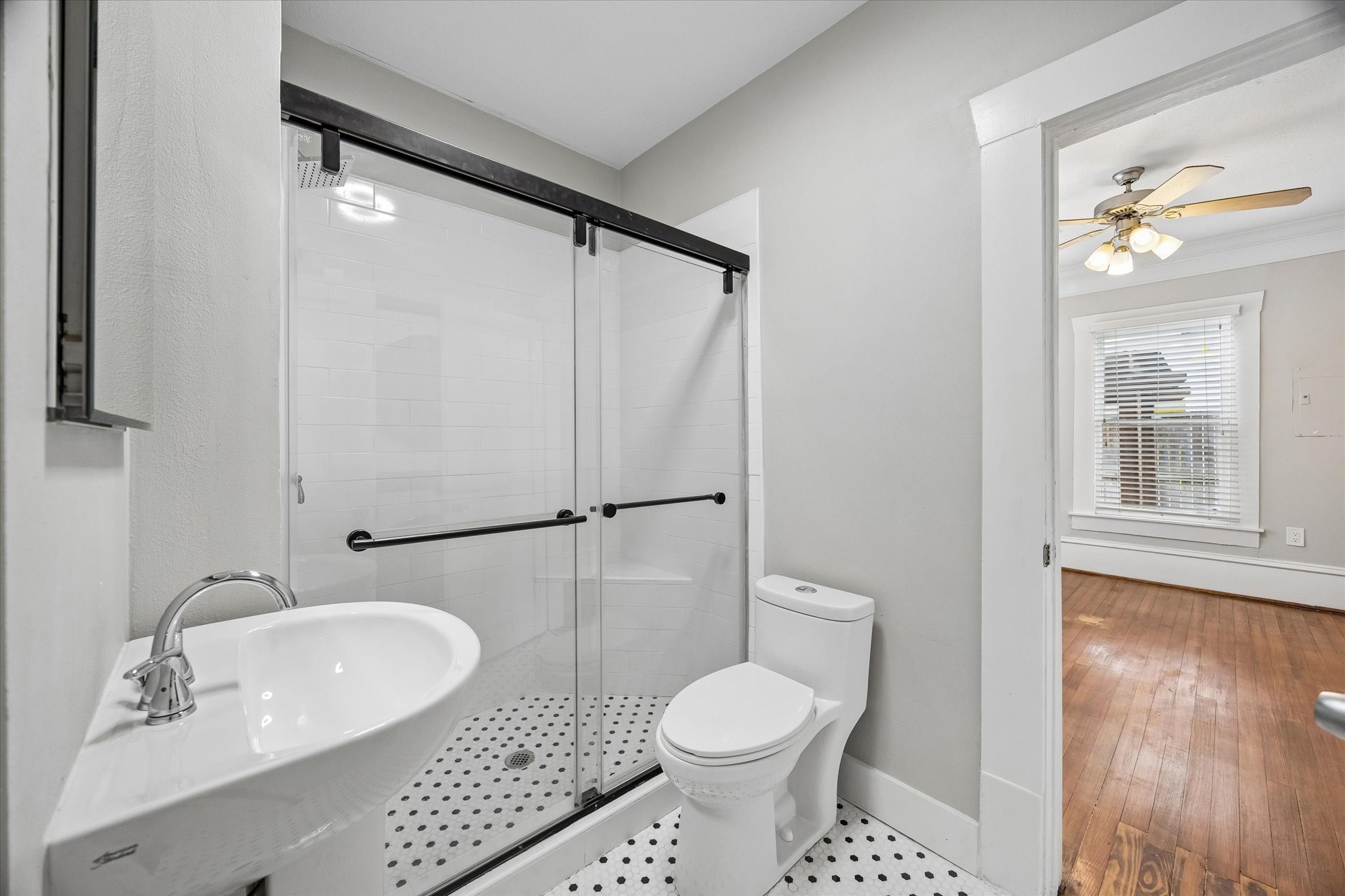 1201 Tulane Street Houston, TX 77008 - Photo 19 of 31 The updated bathroom feels clean, stylish, and perfectly suited to this Historic Heights Craftsman. Black and white tile, a glass shower enclosure, modern fixtures, and easy access from the bedroom give this space the right mix of vintage character and everyday comfort.