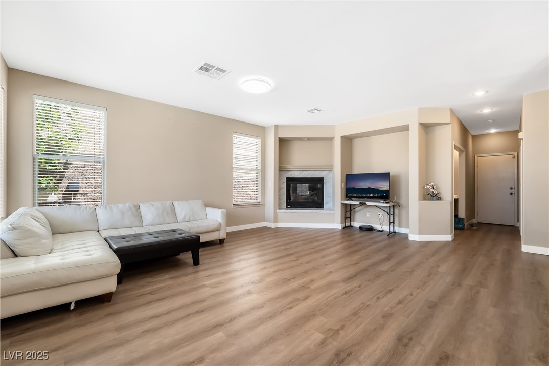 2392 Rainswept Avenue Henderson, NV 89052 - Photo 19 of 49 Living area featuring recessed lighting, visible vents, baseboards, a fireplace, and light wood-style flooring