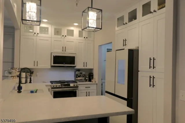 a kitchen with stainless steel appliances a refrigerator sink and cabinets