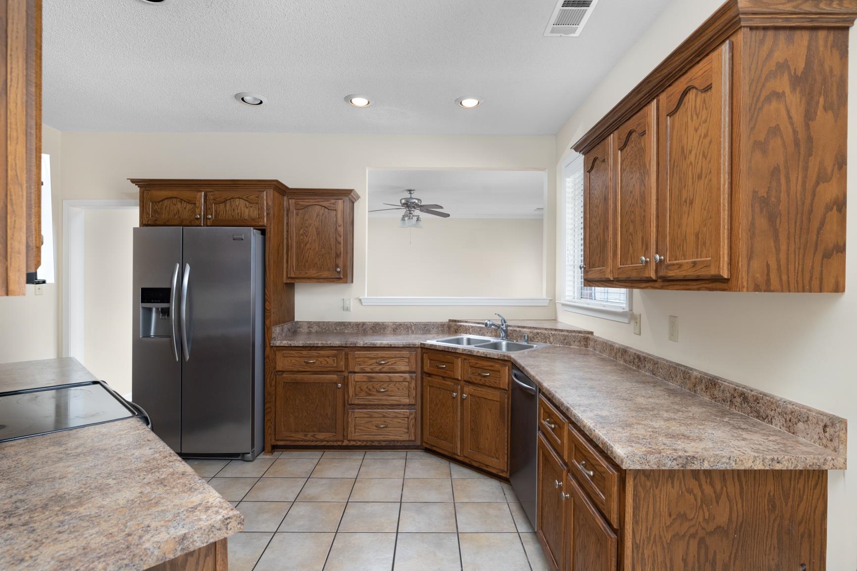 471 Farmer Trail Atoka, TN 38004 - Photo 13 of 35 Kitchen with appliances with stainless steel finishes, brown cabinetry, light tile patterned flooring, recessed lighting, and ceiling fan