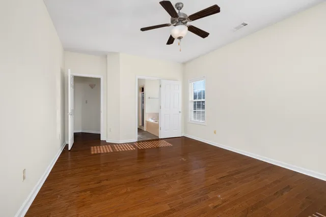 an empty room with a window and a fan
