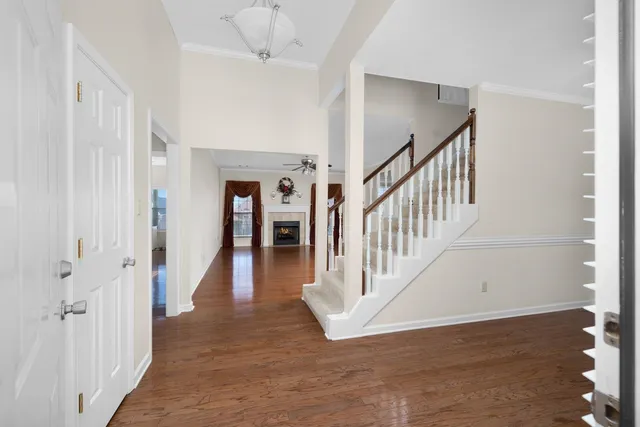 a view of a hallway with wooden floor and a chandelier