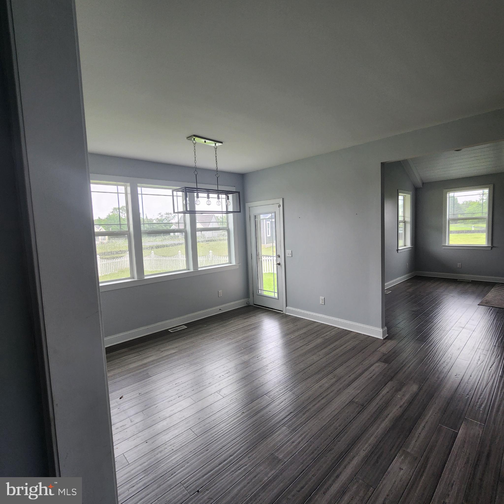 15050 Sandpiper Road Milton, DE 19968 - Photo 11 of 25 an empty room with wooden floor and windows