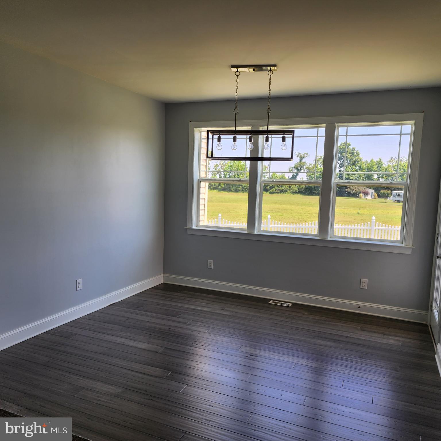 15050 Sandpiper Road Milton, DE 19968 - Photo 12 of 25 an empty room with wooden floor and windows