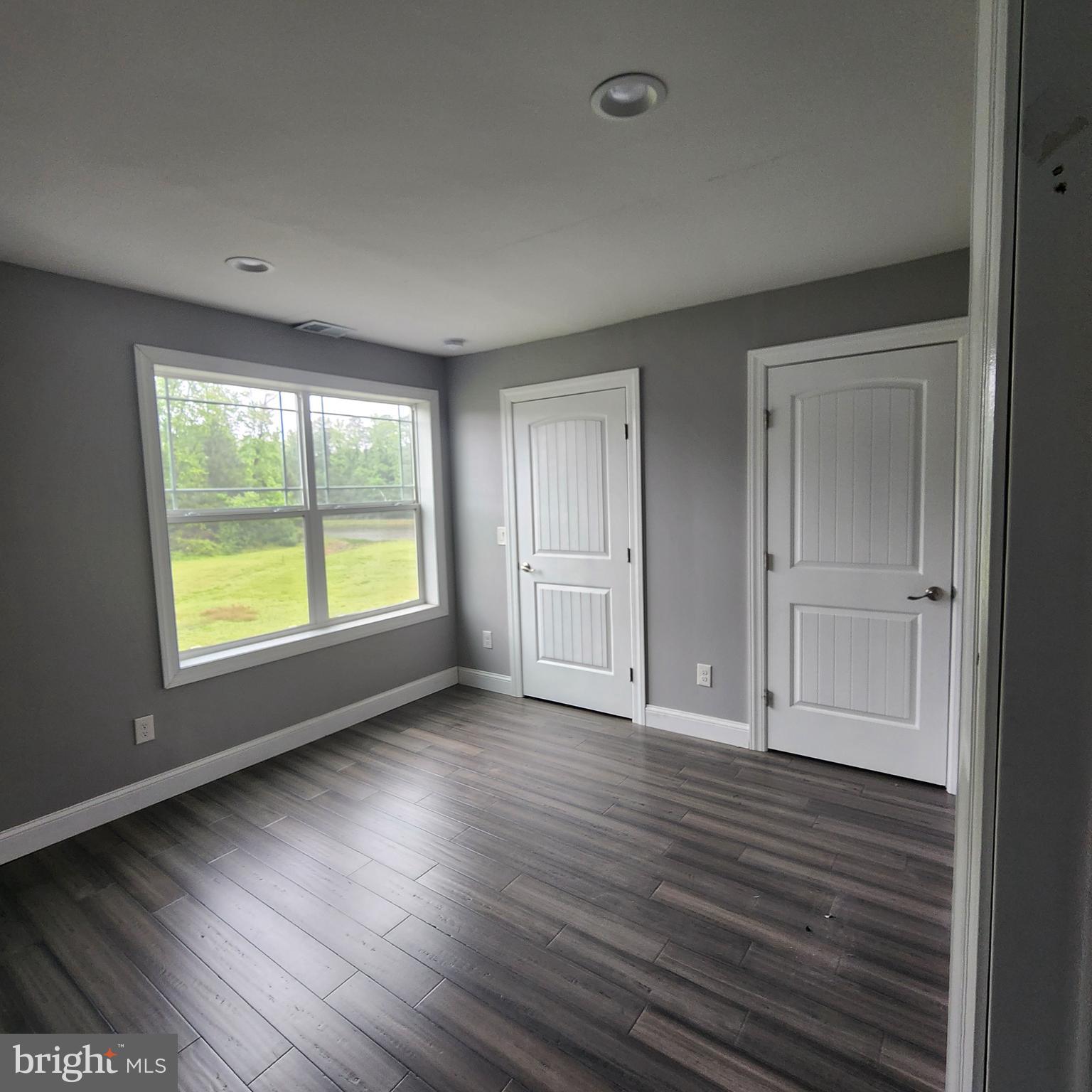 15050 Sandpiper Road Milton, DE 19968 - Photo 15 of 25 a view of an empty room with wooden floor and a window