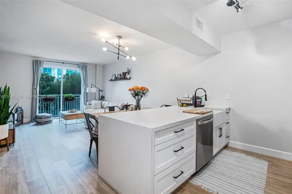 a view of a kitchen sink and wooden floor