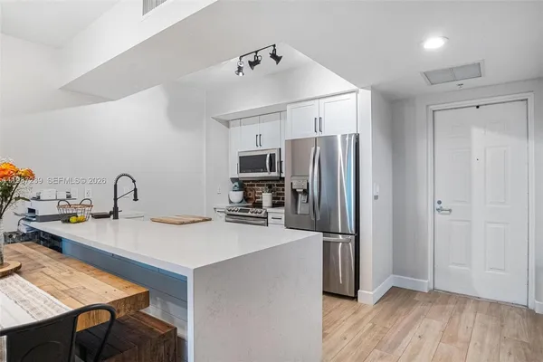 a kitchen with granite countertop a refrigerator and a sink