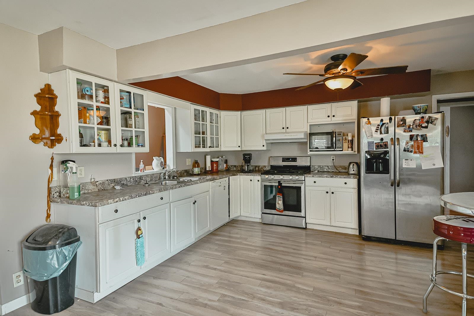 9563 East Center Road Stockton, IL 61085 - Photo 10 of 24 a kitchen with granite countertop a refrigerator a sink dishwasher a stove and white cabinets with wooden floor