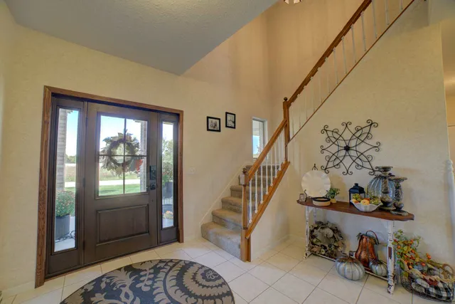 a view of a dining room and livingroom with furniture wooden floor a chandelier
