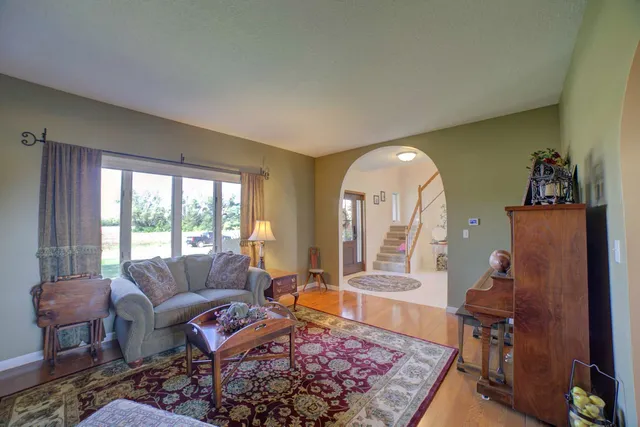 a living room with furniture kitchen view and a window